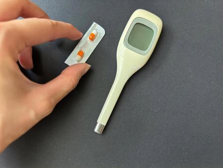 体温計の横にある薬を取る 体温計の横にある薬を取る 体温計,水銀,熱の写真素材