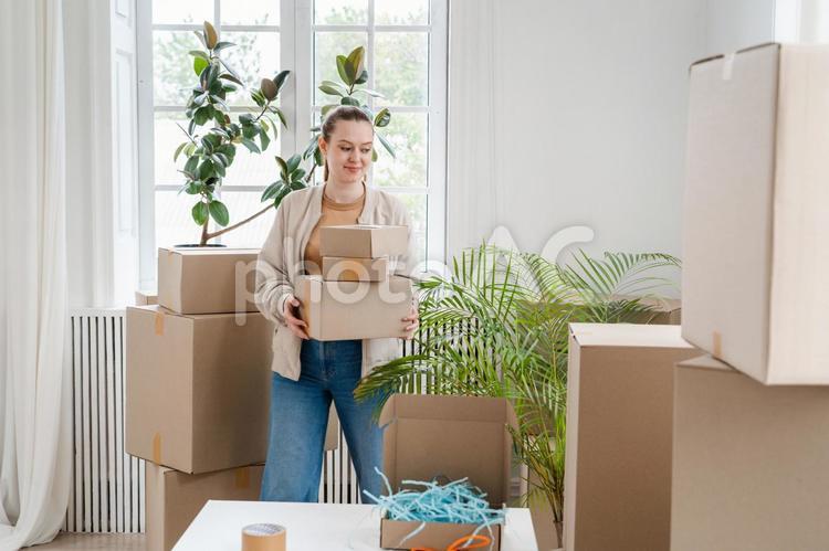 段ボールを重ねて持つ女性 女性,段ボール,重ねるの写真素材