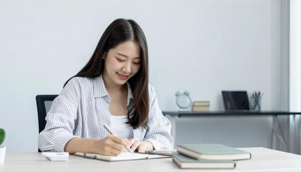 ノートに目標を書き込む女性のイメージの写真