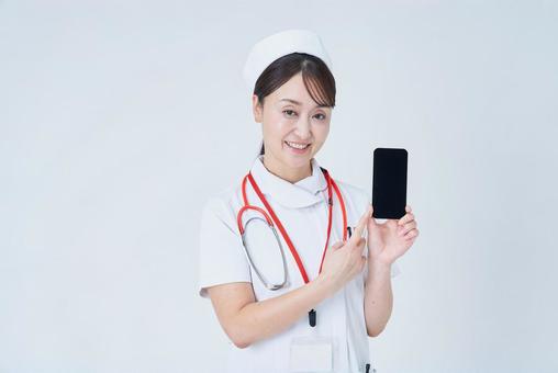 スマートフォンを持つ医療スタッフの女性 スマートフォンを持つ医療スタッフの女性 看護師,医療従事者,スマホの写真素材