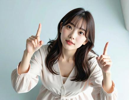 上を指差す女性 上を指差す女性の写真
