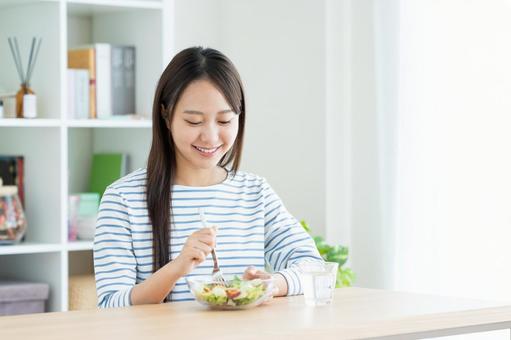 サラダを食べる若い女性 サラダを食べる若い女性の写真