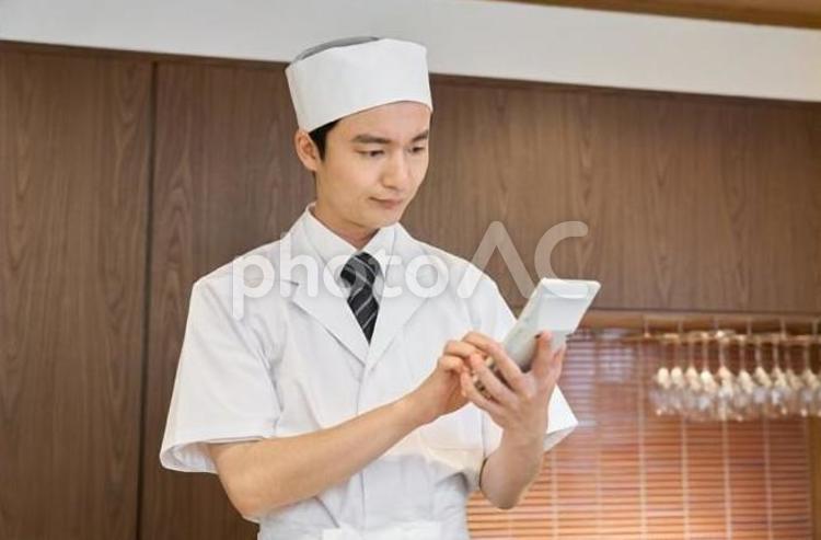 電卓で計算する和食の料理人 電卓,料理人,男性の写真素材