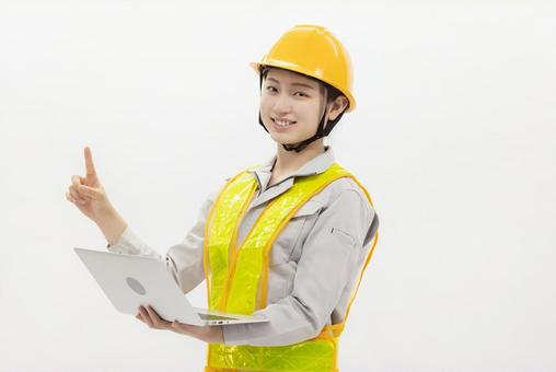 ノートパソコン 作業服の女性 ノートパソコン 作業服の女性 女性,作業員,指差しの写真素材