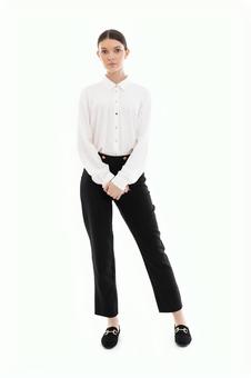 肩幅に足を開き立つカメラ目線の女性 肩幅に足を開き立つカメラ目線の女性の写真