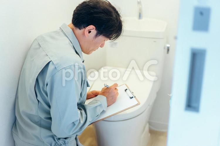 トイレのチェックをする作業着の男性 トイレ,トイレ修理,修理の写真素材