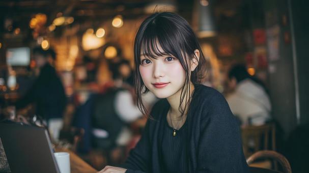 カフェでノートパソコンを使用する女性の写真