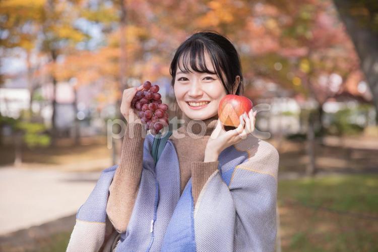 ぶどうとりんごを持つ女性 フルーツ,フルーツ狩り,ぶどうの写真素材