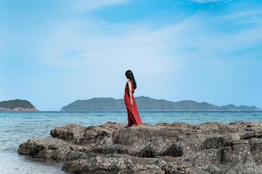 海辺に立つ赤いワンピースの女性① 海辺に立つ赤いワンピースの女性① 女性,海,赤いワンピースの写真素材