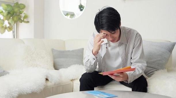 督促状を確認するアジア人男性 督促状,催促,封筒の写真素材