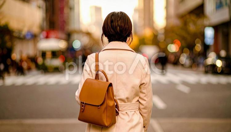 街中を歩いていくリュック姿の女性の後ろ姿 女性,バックパッカー,バックパックの写真素材