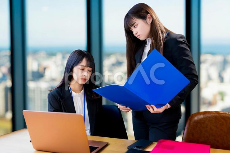 ファイルを持った上司に怒られる女性会社員 女性,ビジネス,ビジネスウーマンの写真素材