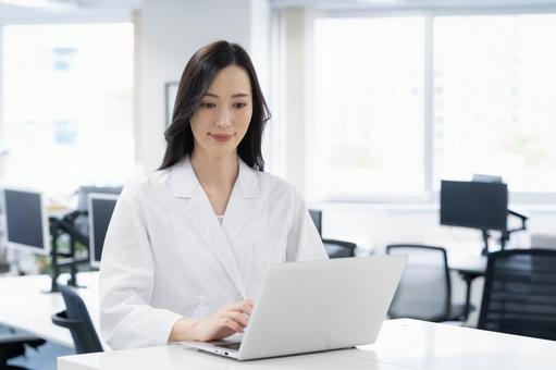 実験をする白衣の若い女性研究者 実験をする白衣の若い女性研究者 サイエンス,研究,実験の写真素材