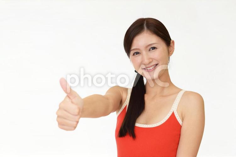 いいねのポーズをとるタンクトップ姿の女性 女性,笑顔,タンクトップの写真素材