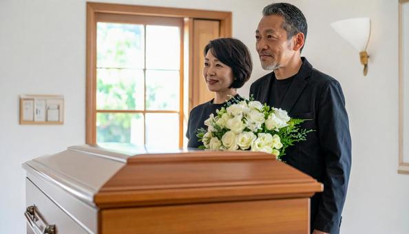 棺を見つめるミドルの男女の写真