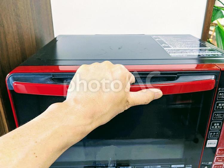 電子レンジの取ってに手をかけたところ 電子レンジ,取って,扉の写真素材