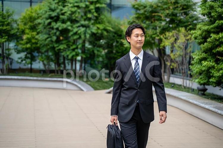 鞄を持って外回り営業する男性ビジネスマン ビジネスマン,男性,屋外の写真素材