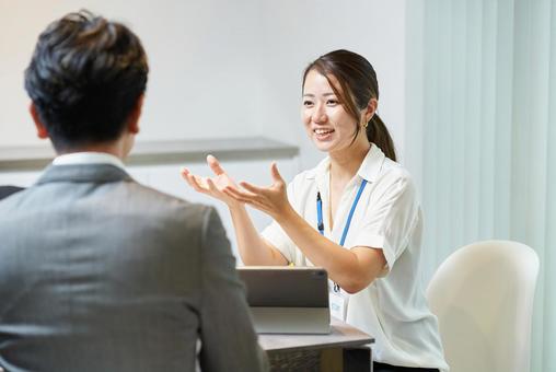 男性と話すオフィスカジュアルな服装の女性 男性と話すオフィスカジュアルな服装の女性 女性,ビジネスウーマン,打ち合わせの写真素材