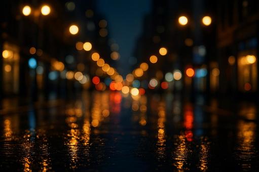 雨に濡れた道路に反射する夜の街の光のボケ 雨に濡れた道路に反射する夜の街の光のボケ 玉ボケ,光,夜景の写真素材