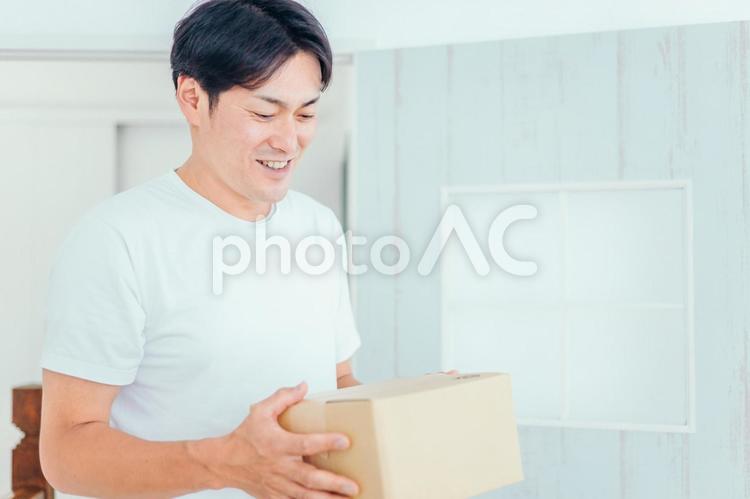 段ボールを運ぶ男性（笑顔） 通販,ネットショッピング,ダンボールの写真素材