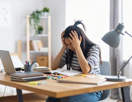 勉強に苦戦する女子学生の悩みの表情 勉強に苦戦する女子学生の悩みの表情の写真