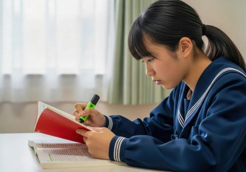 真剣に参考書を読む女子学生 真剣に参考書を読む女子学生の写真