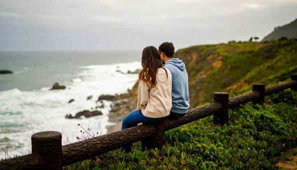 海辺に座るカップルの写真