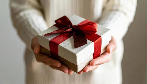 白い箱のプレゼントを両手に取る女性の手 白い箱のプレゼントを両手に取る女性の手の写真