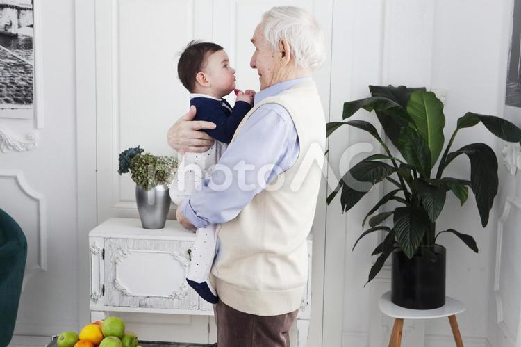 孫を抱っこしてあやすおじいさん 祖父母,孫,子守りの写真素材