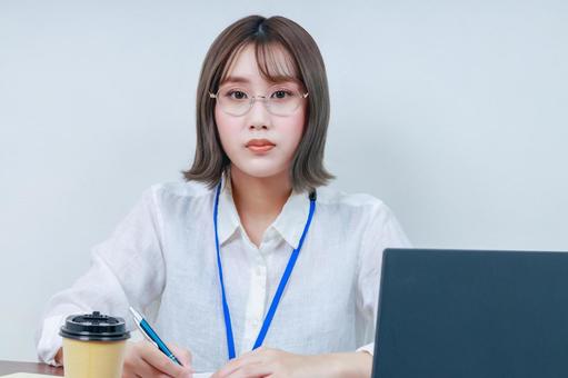 デスクワークする若い女性|カメラ目線 デスクワークする若い女性|カメラ目線 女性,若い,眼鏡の写真素材