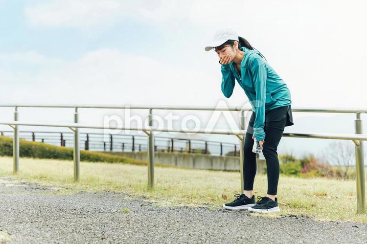 運動中に吐き気・めまいで困るアジア人女性 吐き気,めまい,吐くの写真素材