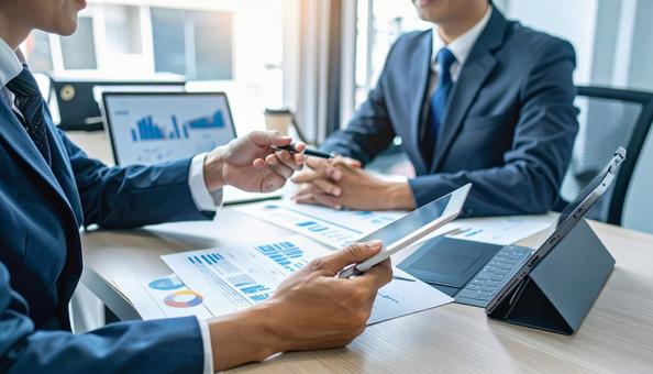 打ち合わせに臨む二人のビジネスマンの写真