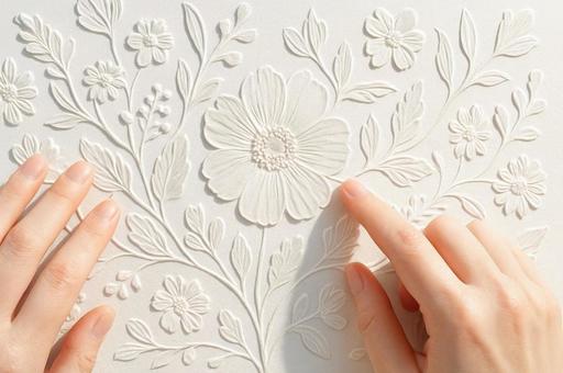 花の浮き彫り模様と指先・エンボス加工 花の浮き彫り模様と指先・エンボス加工の写真