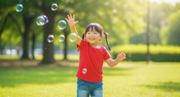 シャボン玉で遊ぶ笑顔の女の子 シャボン玉で遊ぶ笑顔の女の子の写真