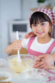 ピンクのエプロンを着た少女のクッキングシーン 女の子,小学生,日本人の写真素材