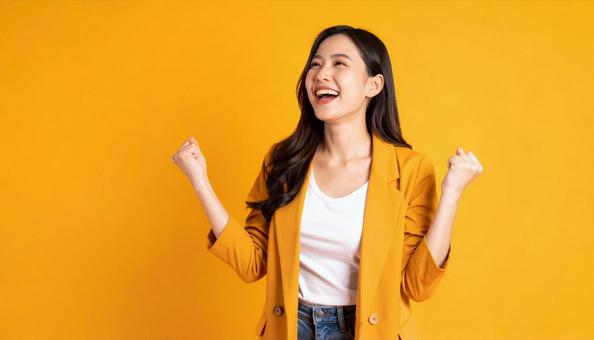 ガッツポーズで喜ぶ女性のポートレート ガッツポーズで喜ぶ女性のポートレートの写真