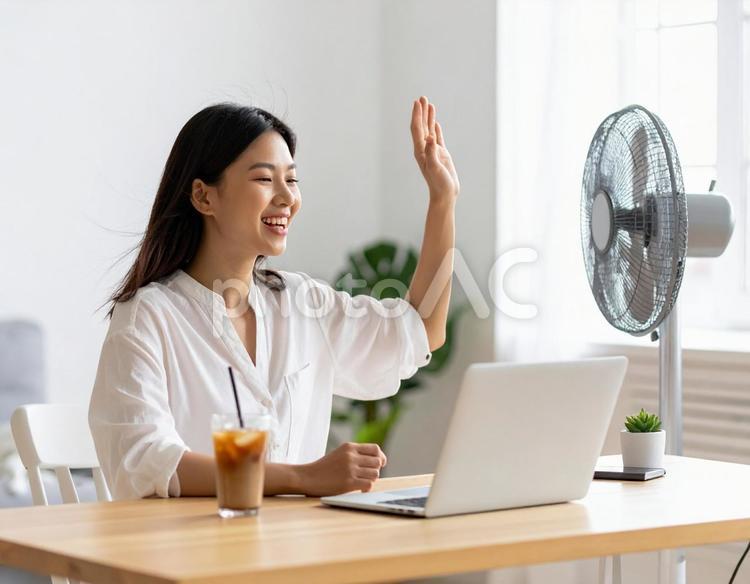 扇風機の風を浴びながら笑顔を見せる女性 女性,扇風機,夏の写真素材