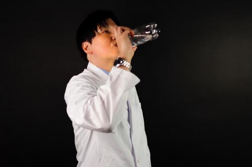白衣の男性が水を飲む 白衣の男性が水を飲むの写真