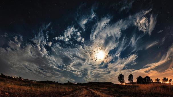 雲間から輝く巨大な満月が照らす夜景 雲間から輝く巨大な満月が照らす夜景の写真