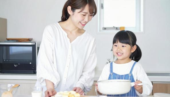 笑顔で料理をする母娘 笑顔で料理をする母娘の写真