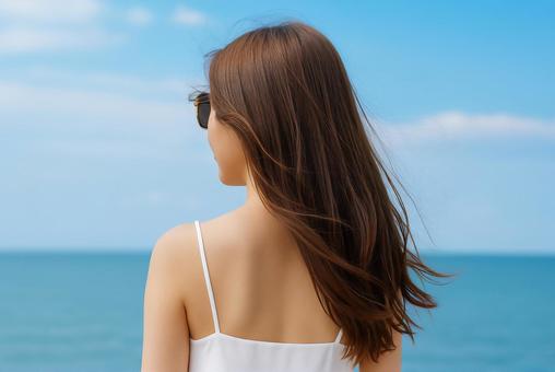 海辺で風を感じる女性の後ろ姿 海辺で風を感じる女性の後ろ姿の写真