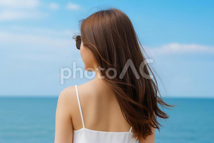 海辺で風を感じる女性の後ろ姿 女性,後ろ姿,海辺の写真素材