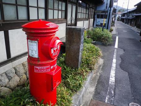 古い町並みに立つ丸型ポスト ポスト,郵便ポスト,丸型ポストの写真素材