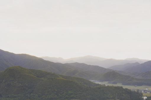 淡い光と霧に包まれた秋の美しい山並み 山,山並み,風景の写真素材