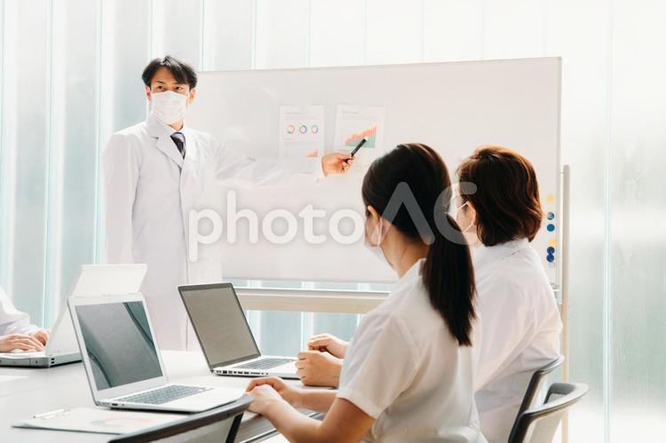会議する白衣姿の男女（マスク） 医療,医者,病院の写真素材