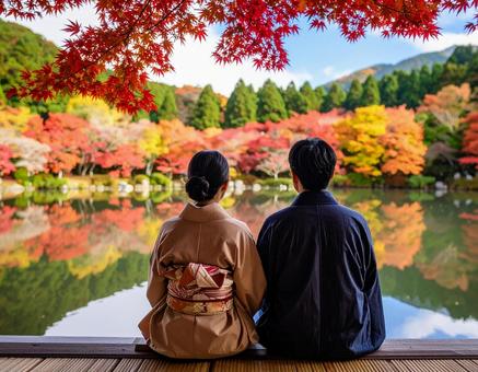 湖畔で紅葉を眺めるカップル 湖畔で紅葉を眺めるカップルの写真