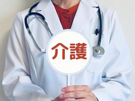 介護と書かれた札を持つ女性医師 介護,医師,要介護の写真素材