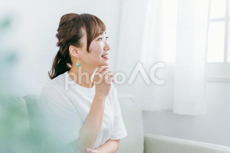 家でリラックスする笑顔の日本人女性の横顔 女性,考える,選ぶの写真素材