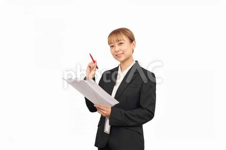赤ペンを持ってるスーツを着た女性 オフィス,先生,講師の写真素材