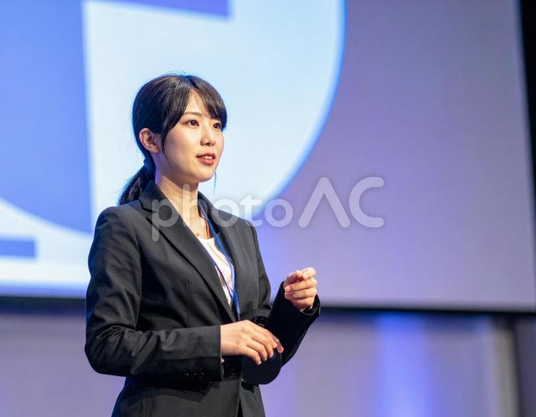 ステージ上でプレゼンをする女性 女性,プレゼン,ビジネスの写真素材